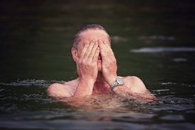 man swims in the lake