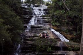 nature waterfall with persons relaxing