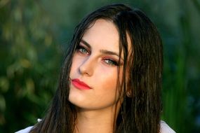 portrait of a beautiful girl with wet hair at blurred green background