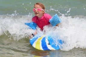 little girl on a surfboard in the surf