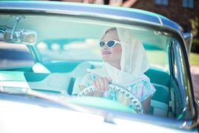 pretty woman in vintage clothes at the wheel