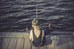 young boy fishing on pier