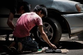 young man repair car wheel