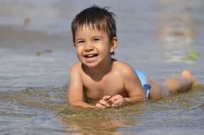 little child laying sea shore