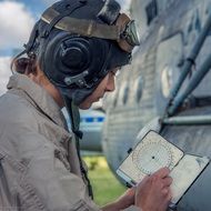 girl pilot with notebook near the plane