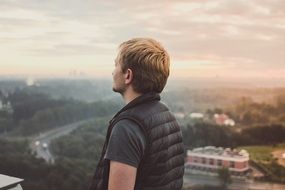young man in a vest on a hill