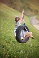 Child playing on the wheel in nature