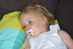 tired little girl with pacifier