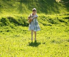 girl with teddy bear on the meadow