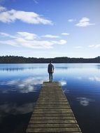 The man at the pier looks at the water