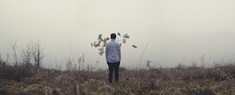 man throws documents on the grass