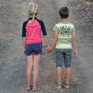 View from behind of children holding hands