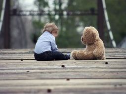 baby and teddy bear on the bridge