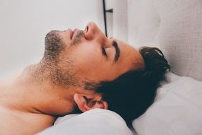 young man sleeping on pillow
