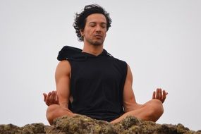 man relaxes through meditation