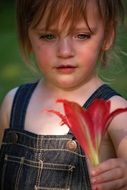 Girl is looking on the red flower