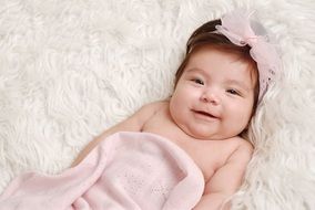 Happy bebe girl lying on a bed