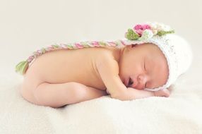 baby girl is sleeping on a white plaid