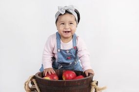 little girl with a bucket of red apples