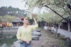 girls smelling flowering spring tree