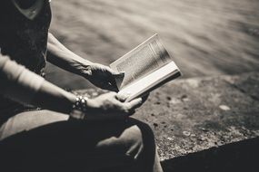 woman reading a book in black and white