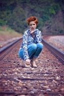 Girl is posing on the railroad tracks