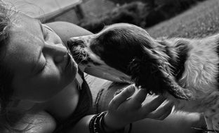 Black and white photo of the girl is playing with her dog