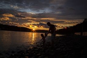 father and daughter on the beach at sunset