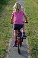 child on a bike on a park path