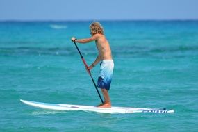 man is swimming on a surfboard