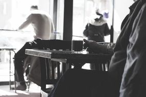 people sitting in cafe in black and white