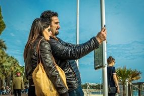 young couple taking pictures on the promenade