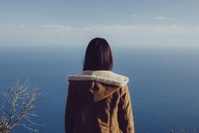 woman looking to ocean, back view