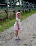 little girl stands on the road
