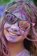 cheerful girl all in multi-colored paint