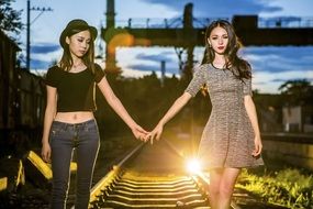 two girls posing on the railway