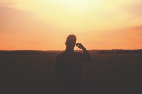 Silhouette of man on the field at dusk