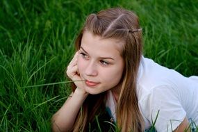 girl lies on green grass in summer