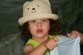 curly-haired baby in a hat