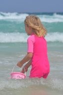 child with bucket in the sea