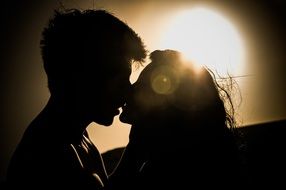 couple in love kisses on a sunset background