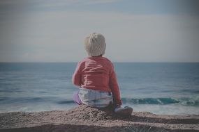 little girl sitting on the beach