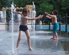 child playing water fontan