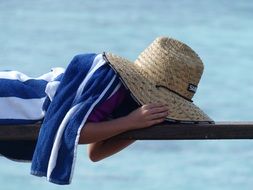 child is lying in a straw hat