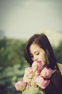 girl is posing with lotus flower bouquet