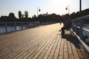 man on the pier bench at sunset