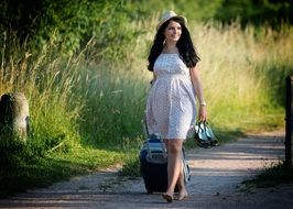 girl with a suitcase goes on the road