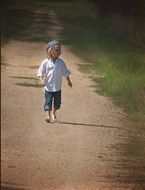 child walks on a dirt road