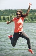 photo of a jumping girl on a lake background