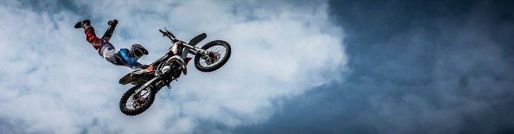 performance of a stunt on a motorcycle high in the sky